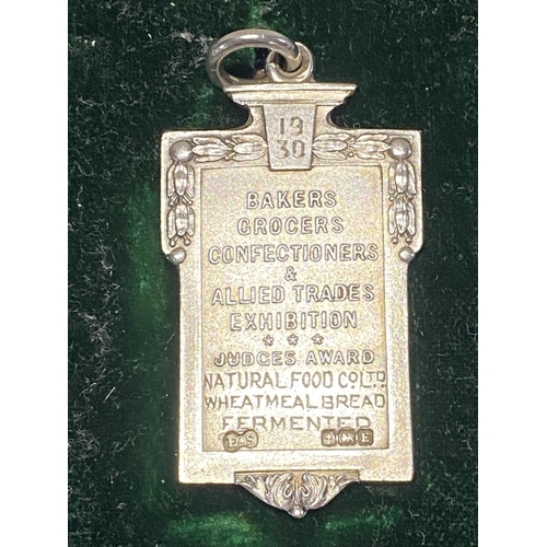 198C - A hallmarked silver medal for 1930 for the bakers & grocers exhibition