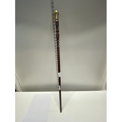 267 - An unusual turned wooden walking cane with brass fittings.  shipping unavailable