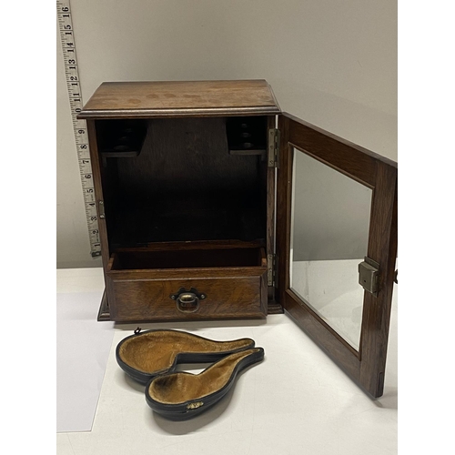 350 - An antique oak smokers cabinet with internal pipe racks and glazed door with key. 30cm x 25 cm plus ... 