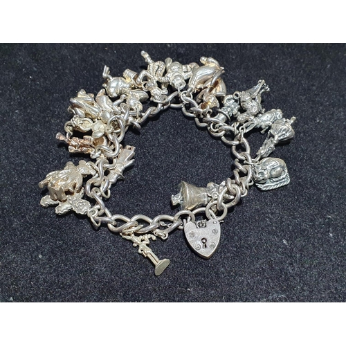 94 - A hallmarked silver bracelet with 925 and white metal charms (Disney themed). Weight 96g