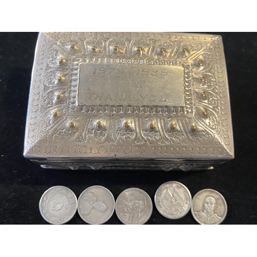 A Chinese white metal box with five Chinese coins