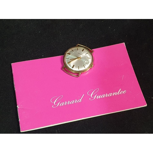 125 - A vintage Garrad wrist watch with date window in working order case tests for 9ct gold overall weigh... 