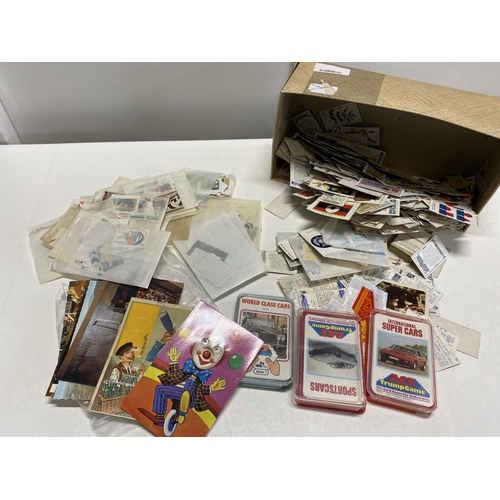 450 - A box of assorted stamps and cigarette cards etc