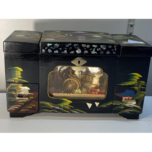 11 - A vintage Japanese lacquered and hand decorated musical jewellery box with moving internal display