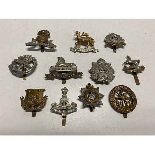 385 - A selection of British military cap badges etc