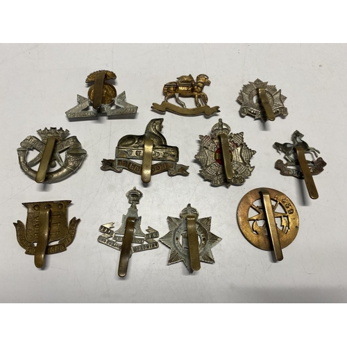 385 - A selection of British military cap badges etc