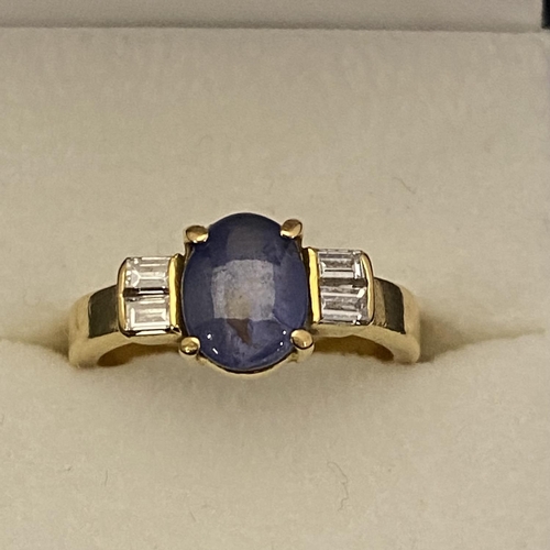 109 - A 18ct gold ring with a rare blue star Sapphire flanked by baguette cut diamonds size m1/2