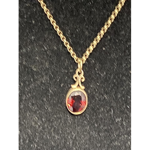 112 - A hallmarked 9ct gold chain with a red stone pendant 3.91g