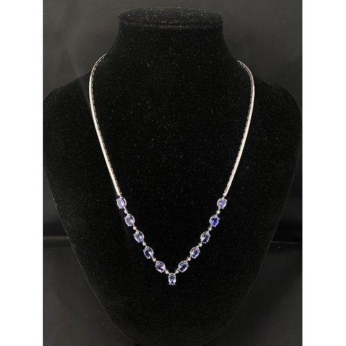 121 - A 18ct white gold necklace set with tanzanite & diamonds. Gross weight 18.42 grams. With cert.