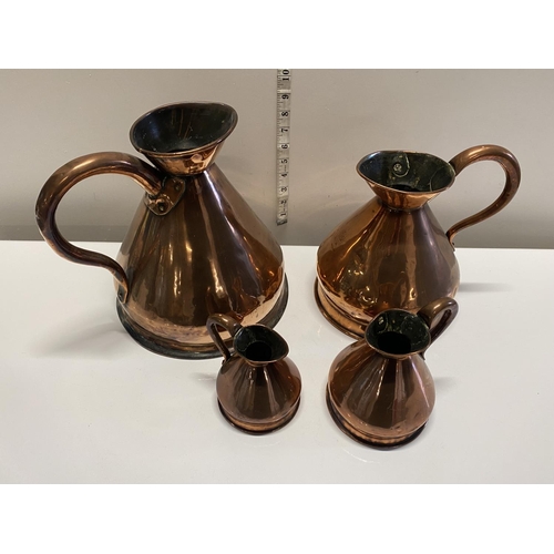 19 - Four antique graduated copper jugs