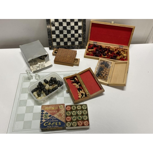 310 - A job lot of assorted chess pieces and boards including travelling examples