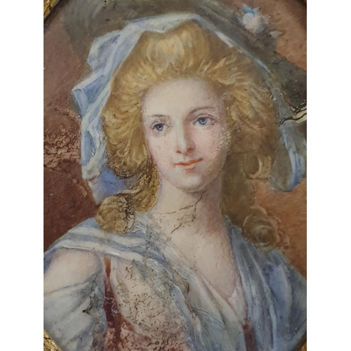 94 - A Georgian painted miniature portrait of a lady in oval brass frame overall dimensions 11x9cm