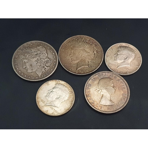 217 - A 1885 Morgan Dollar, 1924 peace dollar, two 1964 half dollar coins and a 1953 Canadian dollar coin.