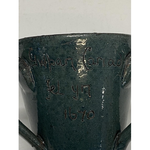 240 - A traditional Welsh loving cup by the claypits pottery. With welsh inscription to front 