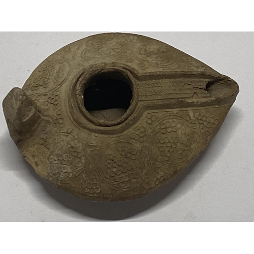 202 - A 12th century Persian Seljuk empire, fired clay oil lamp with grape decoration.