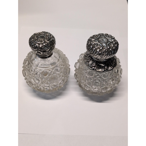 151 - Two Edwardian English Sterling Silver and Cut Glass Lidded Bottles. H 9cm, 7cm dia