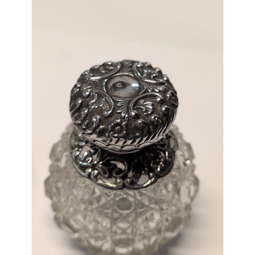 151 - Two Edwardian English Sterling Silver and Cut Glass Lidded Bottles. H 9cm, 7cm dia