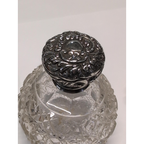 151 - Two Edwardian English Sterling Silver and Cut Glass Lidded Bottles. H 9cm, 7cm dia