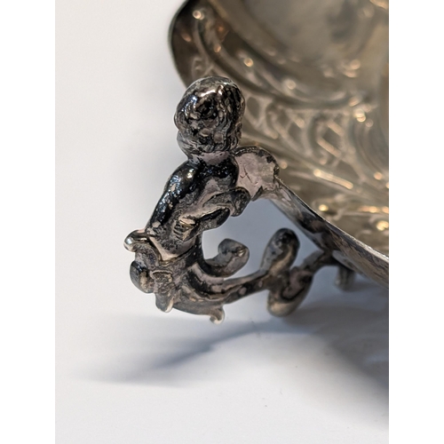 164 - Exeter 1862? Silver Repoussé Dish with Figural Putti Handles. H 3.5cm, L 19cm, W 13cm 148g