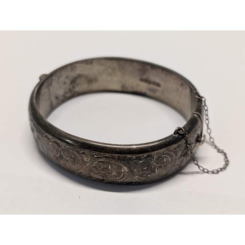 173 - A Vintage Sterling Silver Floral Engraved Hinged Bangle. H 2cm, 7cm dia