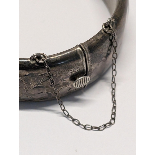 173 - A Vintage Sterling Silver Floral Engraved Hinged Bangle. H 2cm, 7cm dia