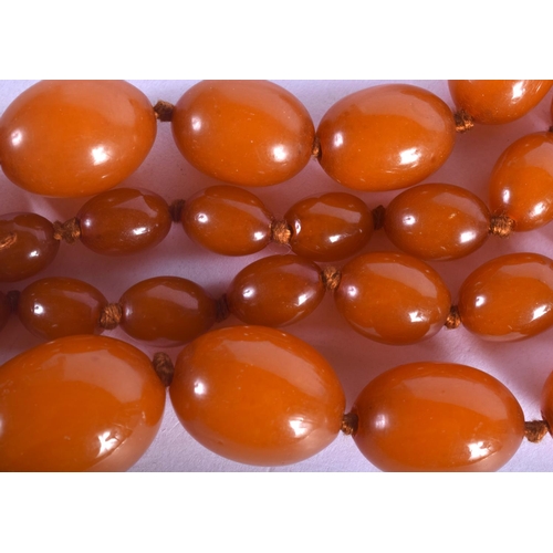 1166 - AN EARLY 20TH CENTURY MIDDLE EASTERN CARVED AMBER NECKLACE of graduated form.77 grams. 72 cm long, l... 