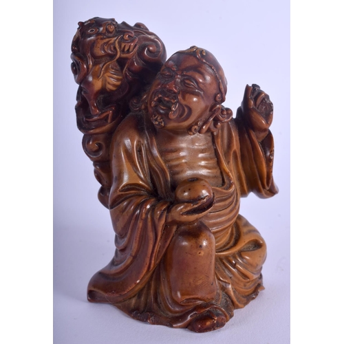 1215 - A 19TH CENTURY CHINESE CARVED SOAPSTONE FIGURE OF AN IMMORTAL Qing, modelled beside a dragon. 9 cm x... 