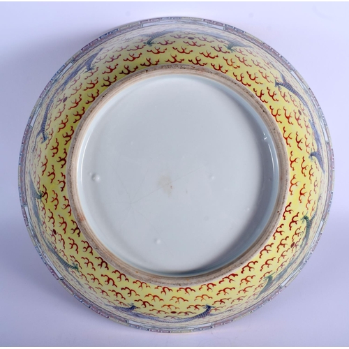 1290 - A LARGE EARLY 20TH CENTURY CHINESE FAMILLE JAUNE BOWL Qing/Republic, painted with dragons amongst cl... 