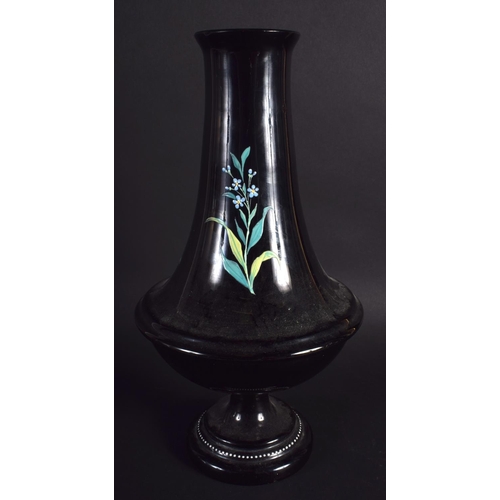17 - A VICTORIAN ENAMELLED BLACK GLASS VASE decorated with floral sprays. 29 cm high.