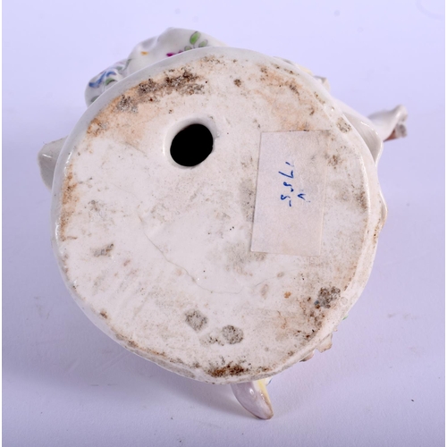 204 - Bow figure of a female musician  seated and playing the flute wearing a flowered dress raised on a p... 