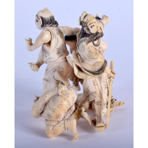 1028 - A 19TH CENTURY JAPANESE MEIJI PERIOD CARVED IVORY OKIMONO modelled as three oni beside a male warrio... 