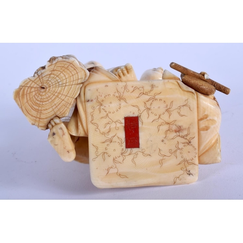 1044 - A 19TH CENTURY JAPANESE MEIJI PERIOD CARVED IVORY OKIMONO modelled as a male picking wax from anothe... 