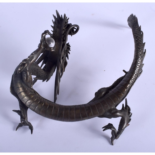 1055 - A 19TH CENTURY JAPANESE MEIJI PERIOD BRONZE DRAGON modelled holding a clear crystal ball. 27 cm x 16... 