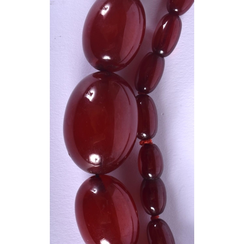 1056 - A 1930S CHERRY AMBER CATALIN TYPE NECKLACE of graduated form. 62 grams. 68 cm long, largest bead 3 c... 