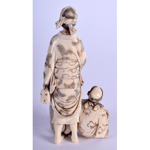 1084 - A 19TH CENTURY JAPANESE MEIJI PERIOD CARVED IVORY OKIMONO modelled as a female beside a boy. 9.5 cm ... 