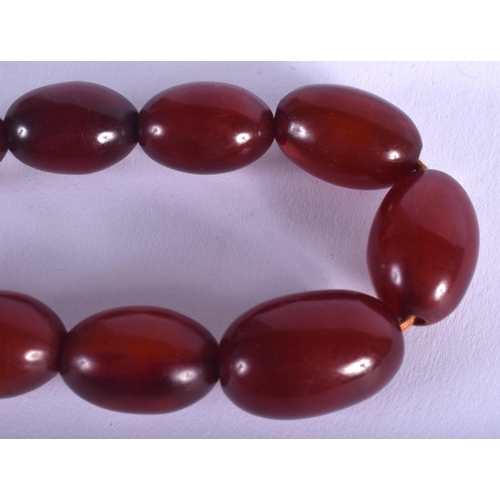 1093 - AN EARLY 20TH CENTURY CARVED RED AMBER BAKELITE TYPE NECKLACE of graduated form. 47 grams. 40 cm lon... 