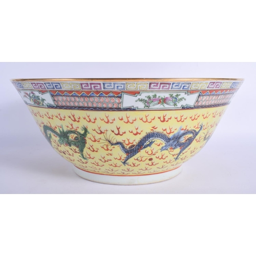 1216 - A LARGE EARLY 20TH CENTURY CHINESE FAMILLE JAUNE BOWL Qing/Republic, painted with dragons amongst cl... 