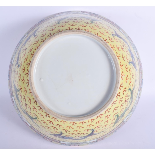 1216 - A LARGE EARLY 20TH CENTURY CHINESE FAMILLE JAUNE BOWL Qing/Republic, painted with dragons amongst cl... 