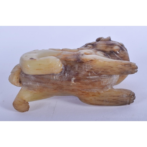 1257 - A CHINESE QING DYNASTY CARVED MUTTON JADE BUDDHISTIC LION modelled roaming and scowling. 9 cm x 6 cm... 