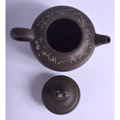 1320 - A CHINESE YIXING POTTERY TEAPOT AND COVER 20th Century, decorated with calligraphy. 11.5 cm wide.