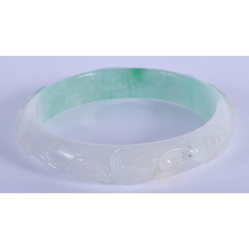 1497 - A CHINESE CARVED JADEITE BANGLE 20th Century. 7 cm diameter.