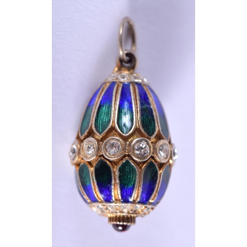 1873 - A SILVER ENAMEL AND RUBY EGG PENDANT. 2.75 cm x 1.5 cm.