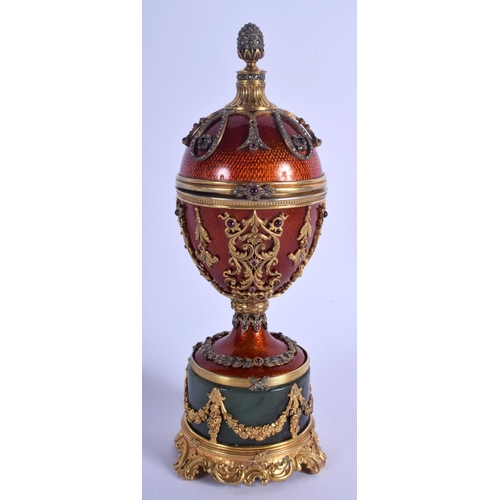 1951 - AN UNUSUAL CONTINENTAL SILVER GILT ENAMEL RUBY AND JADE EGG overlaid with foliage and vines. 566 gra... 