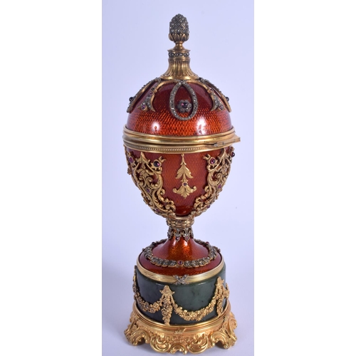 1951 - AN UNUSUAL CONTINENTAL SILVER GILT ENAMEL RUBY AND JADE EGG overlaid with foliage and vines. 566 gra... 