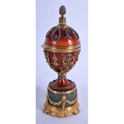 1951 - AN UNUSUAL CONTINENTAL SILVER GILT ENAMEL RUBY AND JADE EGG overlaid with foliage and vines. 566 gra... 