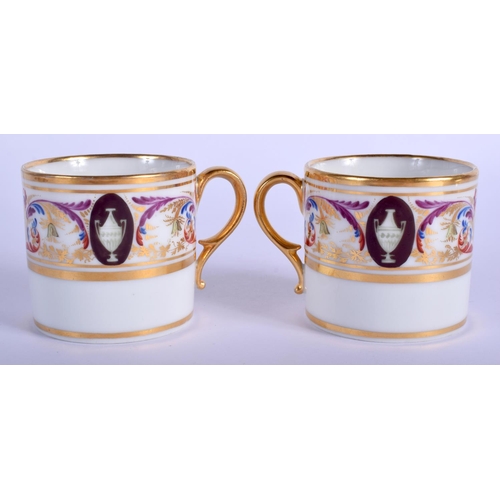 198 - La Courtille pair of coffee cans and stands painted in neoclassical style with urns.