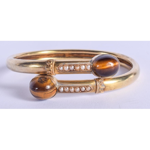 2166 - A VICTORIAN 15CT GOLD PEARL AND TIGERS EYE BANGLE. 14 grams. 5.5 cm wide.