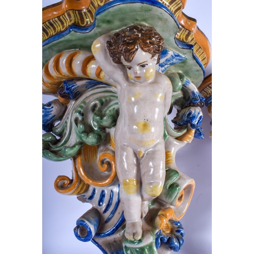 294 - A LARGE PAIR OF 19TH CENTURY FRENCH FAIENCE GLAZED MAJOLICA BRACKET formed with putti amongst foliag... 