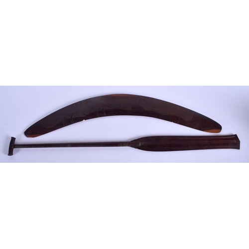 321 - A TRIBAL AUSTRALIAN CARVED WOOD BOOMERANG together with a palm wood paddle. Largest 62 cm long. (2)