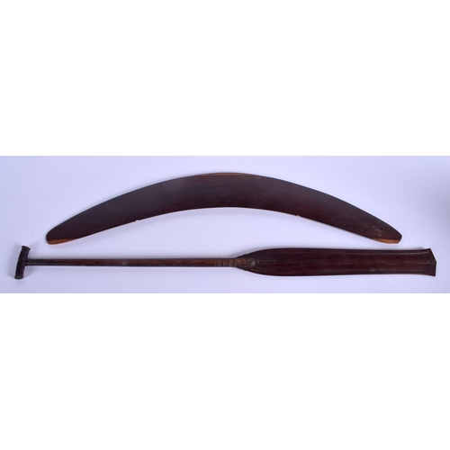 321 - A TRIBAL AUSTRALIAN CARVED WOOD BOOMERANG together with a palm wood paddle. Largest 62 cm long. (2)